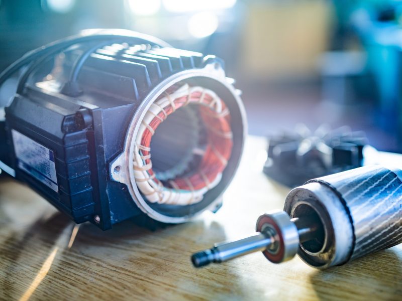 Close-up of an iron industrial motor lies on a table during the production of new modern trucks in a factory. The concept of reliable and high-quality special cars